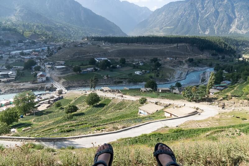 feet dangling over seat- view of valley and hills. Swat Valley Kalam