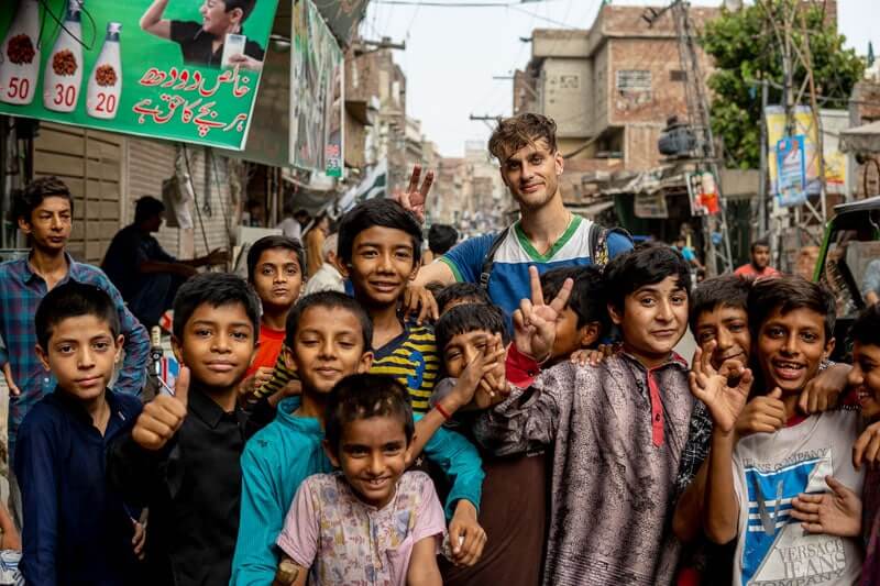 white guy with a bunch of Pakistani boys posing for a picture