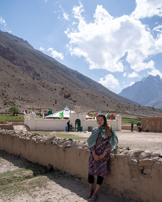 girl standing in front of chapursan valley shrine